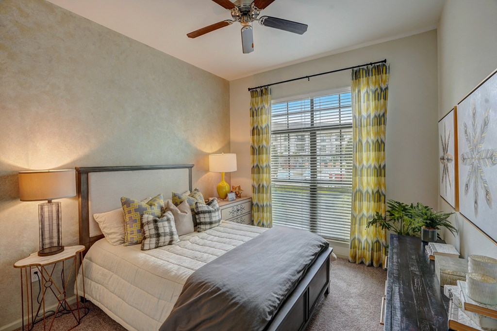 a bedroom with a large bed and a ceiling fan