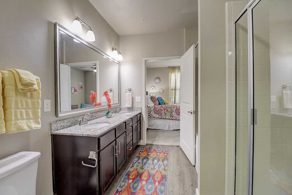 a bathroom with a shower and a sink and a mirror