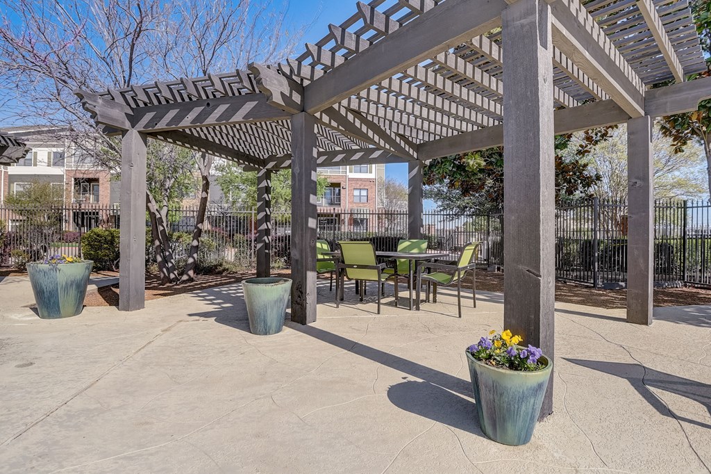 a patio with a pergola and tables and chairs