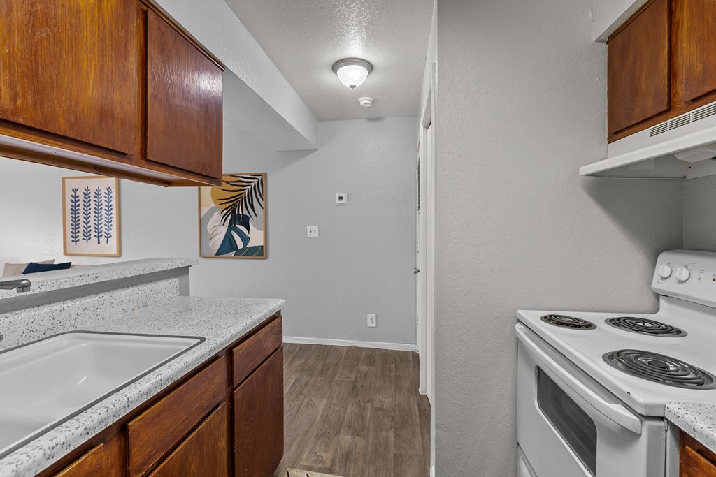 the kitchen of our studio apartment atrium with white appliances and wood cabinets
