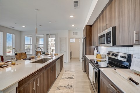 A modern kitchen with wooden cabinets and stainless steel appliances.