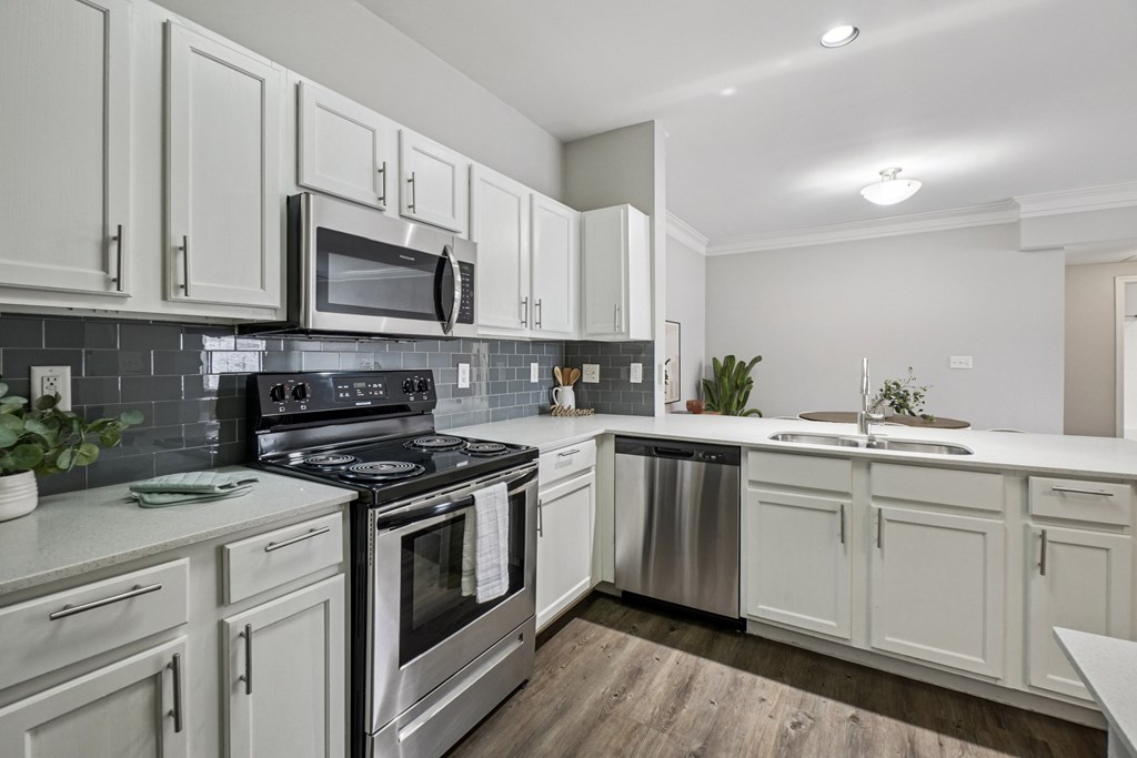 A kitchen with white cabinets and a black stove top oven.
