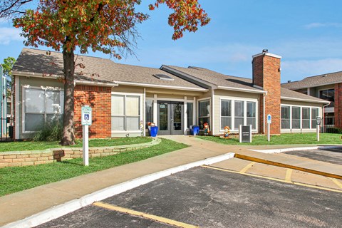 A parking lot in front of a building with a tree.