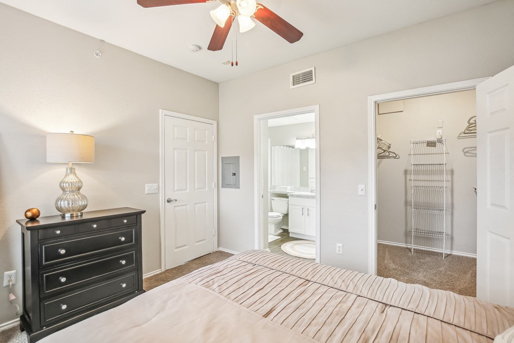 A bedroom with a bed, dresser, and mirror.
