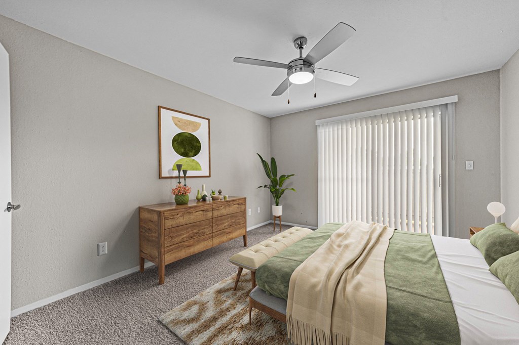 an empty bedroom with a bed and a ceiling fan