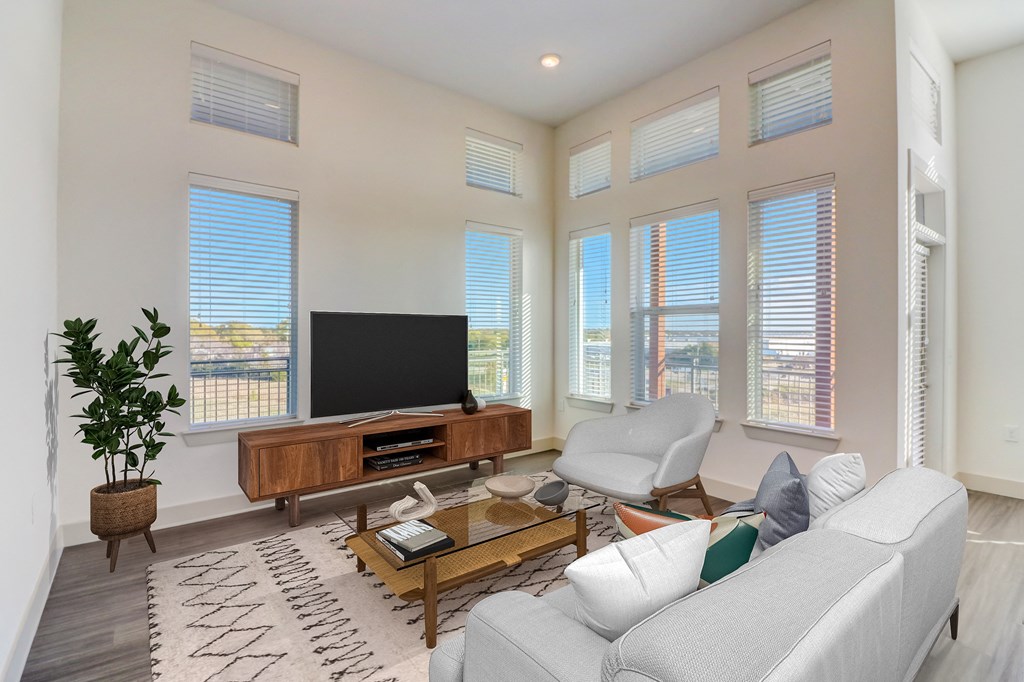 a living room with a white couch and a television