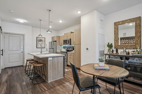 A modern kitchen with a dining table and chairs.