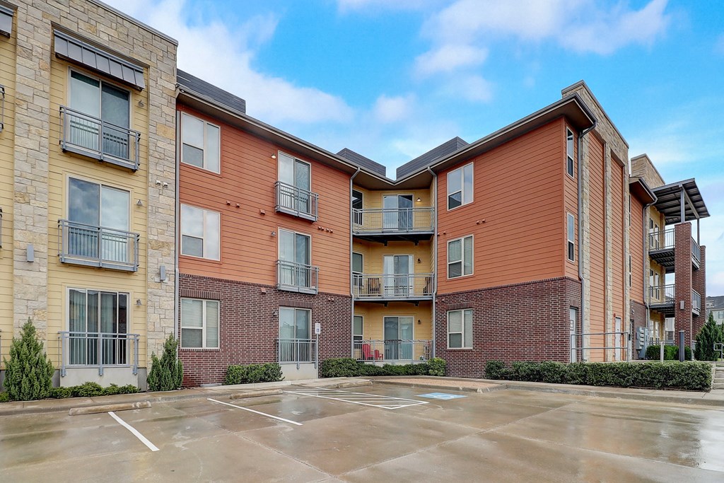 an empty parking lot in front of an apartment building