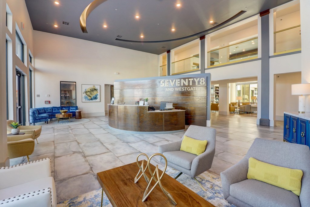 a lobby with couches and a table and a reception desk