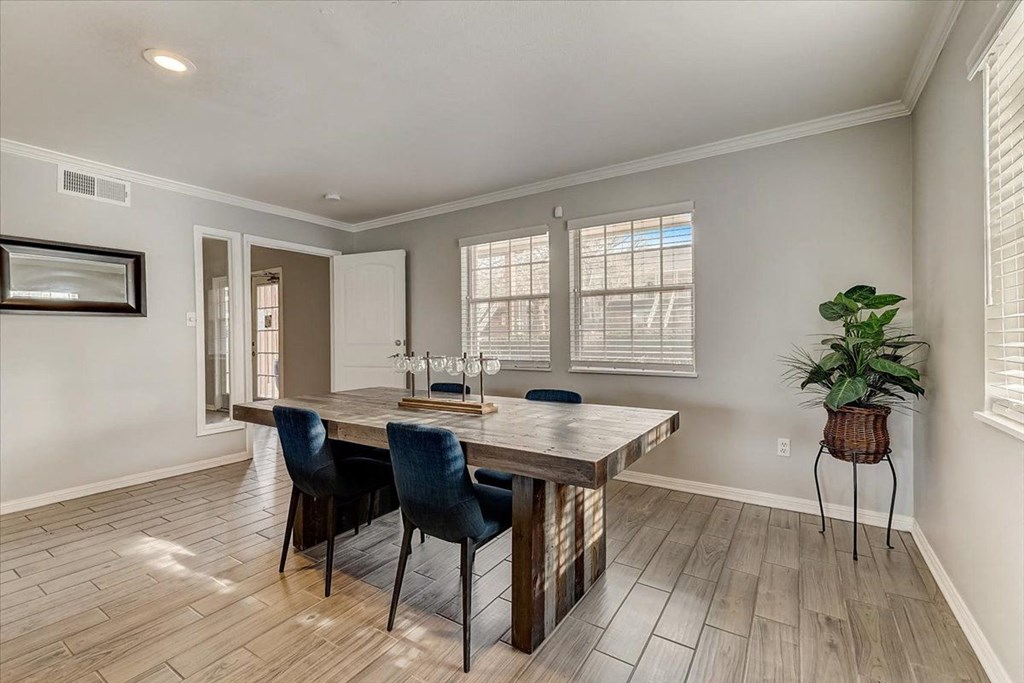 a dining room with a wooden table and chairs