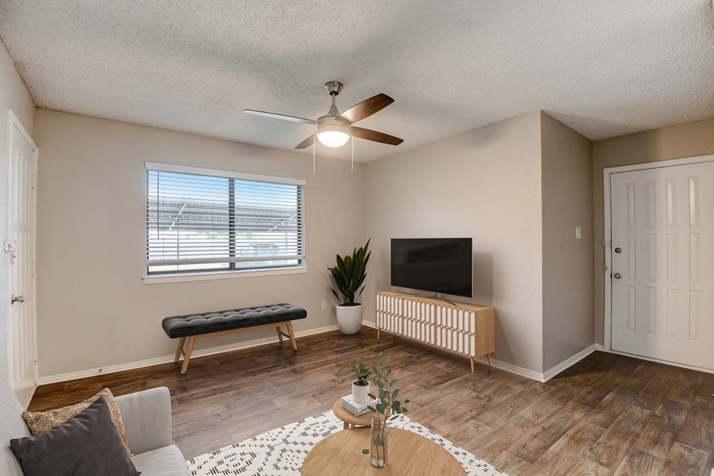 a living room with a ceiling fan and a window