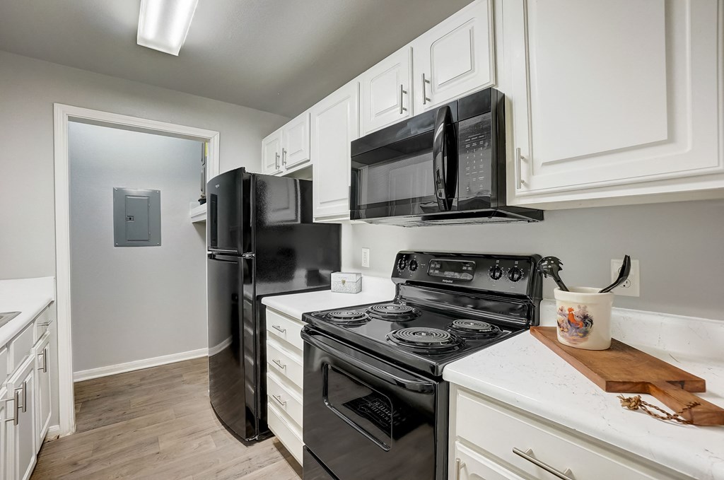a kitchen with black appliances and white cabinets and a black refrigerator