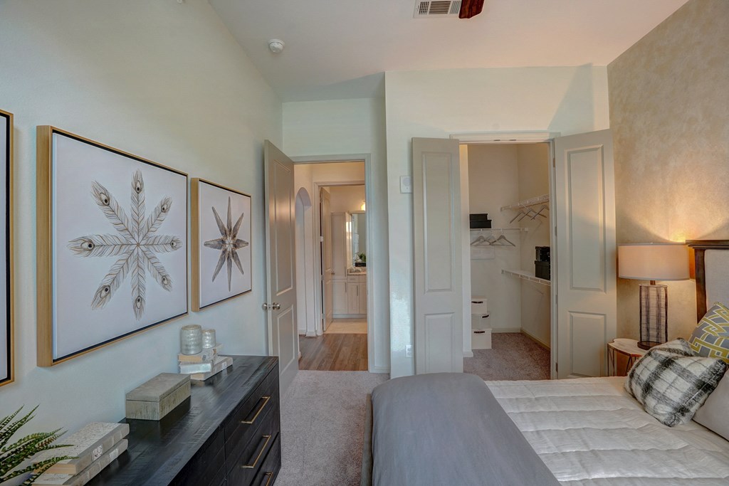 a bedroom with a bed and a dresser and a bathroom