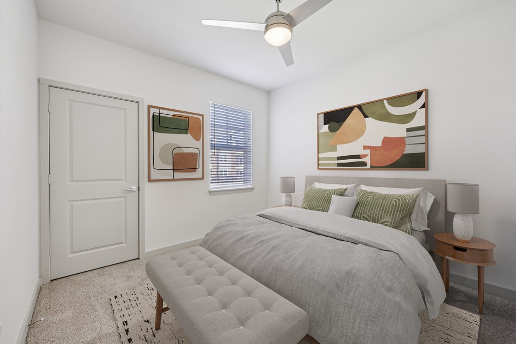 A bedroom with a bed, a bench, and a painting on the wall.