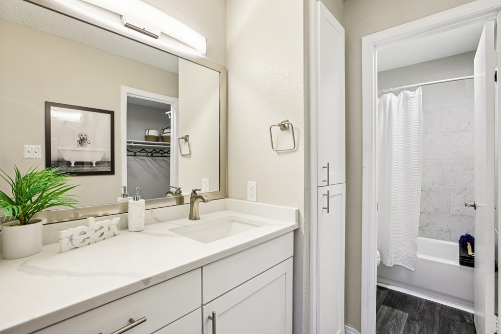 A bathroom with a white sink and a white door.