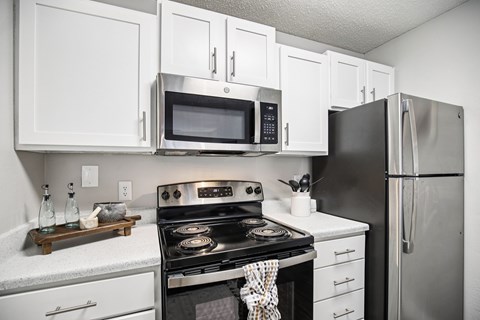 A modern kitchen with white cabinets and stainless steel appliances.