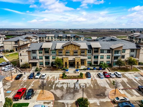 an aerial view of a building with cars parked in front of it