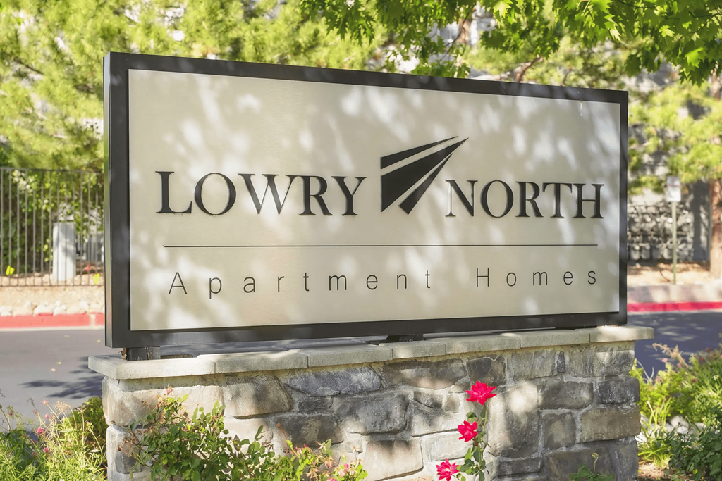 a sign for lowry north apartment homes in front of a stone wall