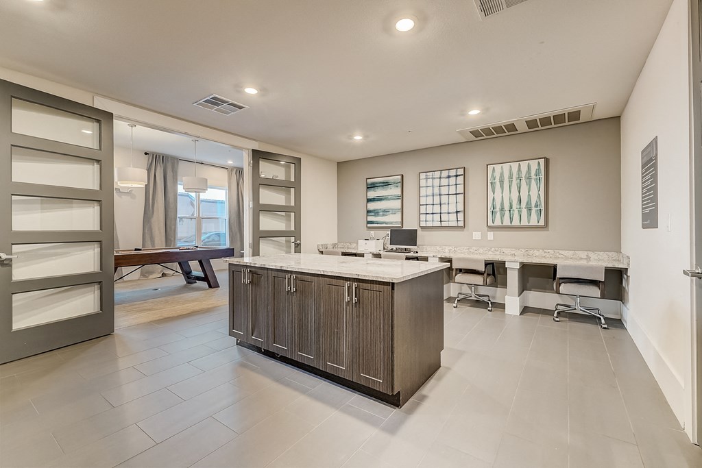 a kitchen with a large island and a desk with a computer