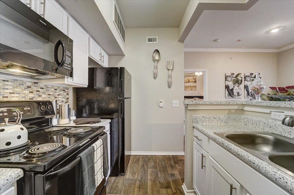 a kitchen with a stove top oven and a sink