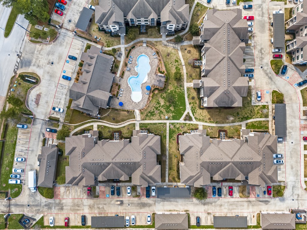 an aerial view of a neighborhood with houses and a swimming pool