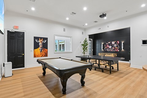 A pool table in a room with a painting of a giraffe on the wall.