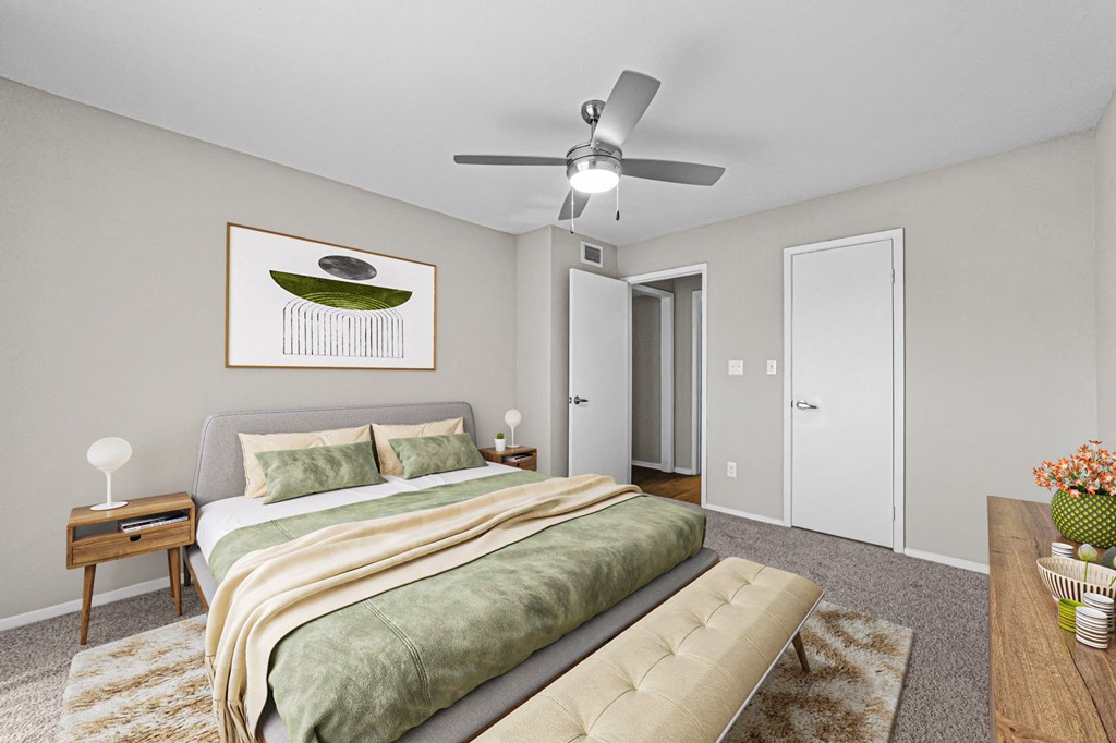 a bedroom with a large bed and a ceiling fan