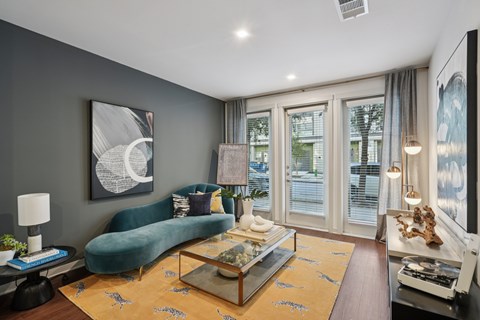 A living room with a green sofa and a coffee table.