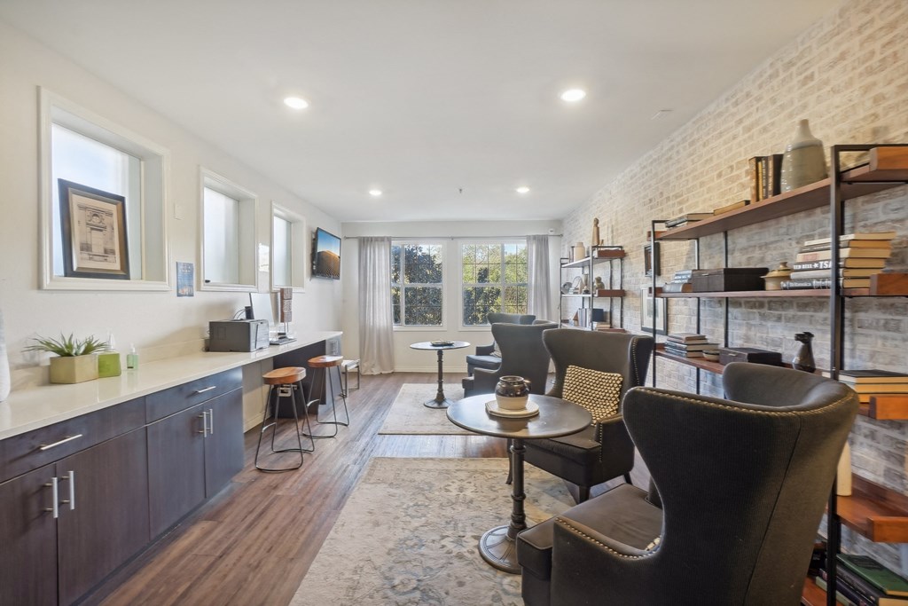 A modern kitchen with dark wood cabinets and a brick wall.