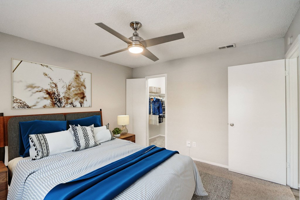 a bedroom with a large bed and a ceiling fan