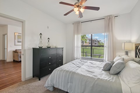 A bedroom with a large bed and a ceiling fan.