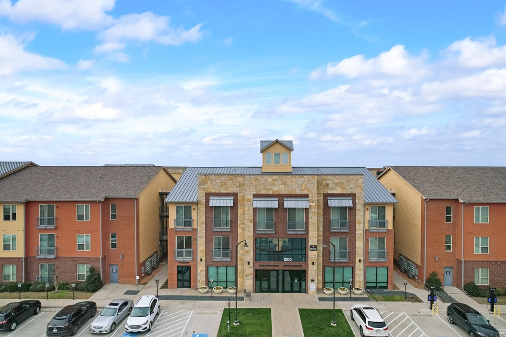an apartment building with cars parked in front of it