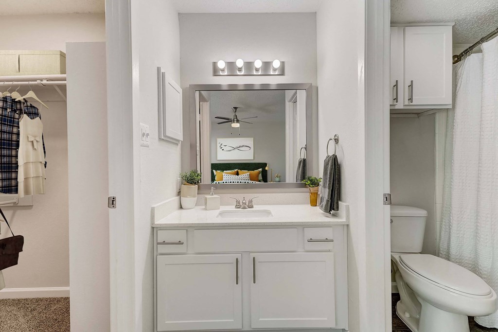 a bathroom with white cabinets and a white toilet