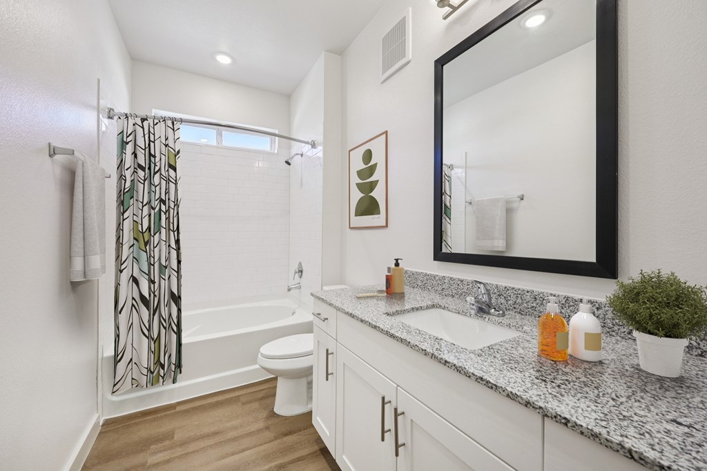 A bathroom with a white toilet, sink, and a mirror.