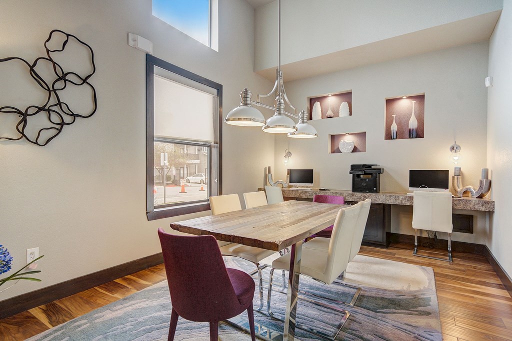 a dining room with a wooden table and chairs and a large window