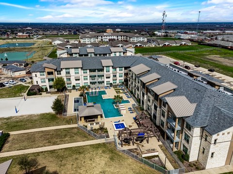 an aerial view of a building with a pool and other buildings