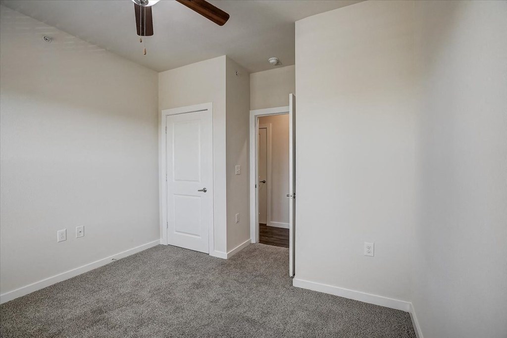a bedroom with carpet and a ceiling fan
