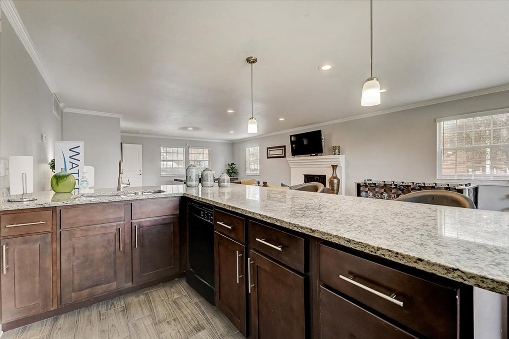 a kitchen with a marble counter top and wooden cabinets