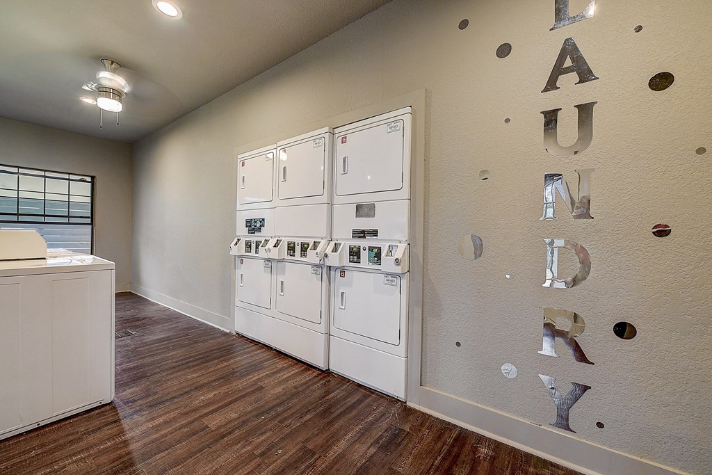 a kitchen with white appliances and a wall with letters on it