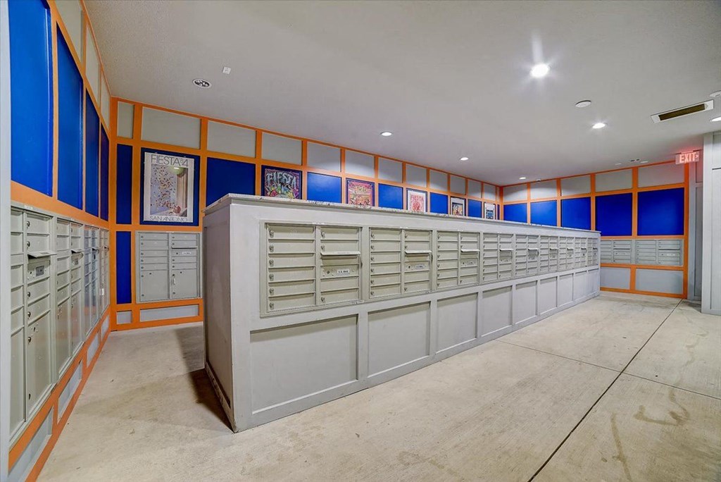 the mail room of a building with many mailboxes and shelves