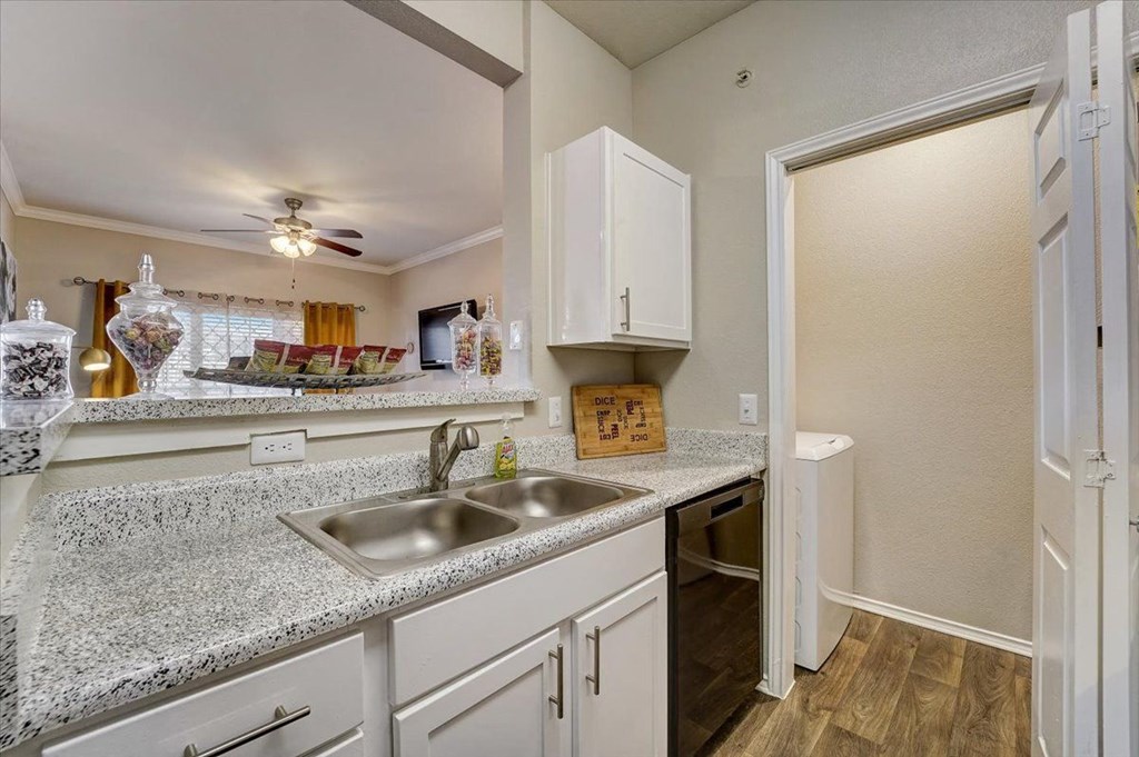 a kitchen with a sink and a door to a bathroom