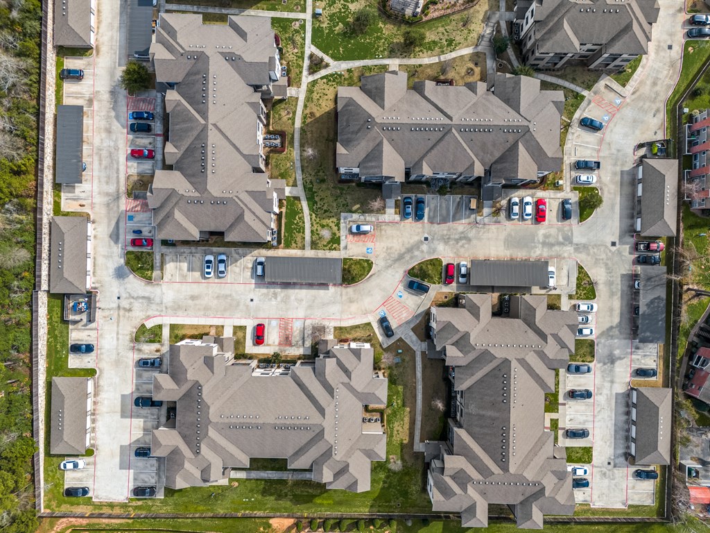 an aerial view of houses with cars parked on the street