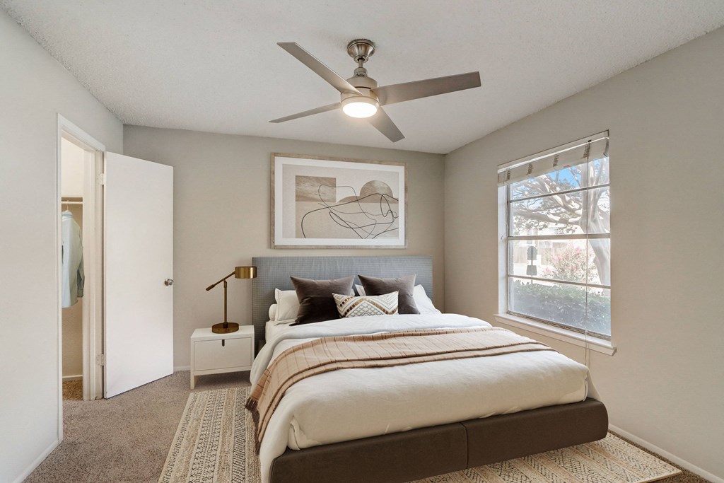 a bedroom with a large bed and a ceiling fan