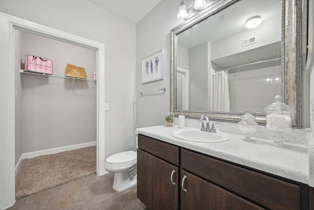A bathroom with a white toilet, a sink, and a mirror.