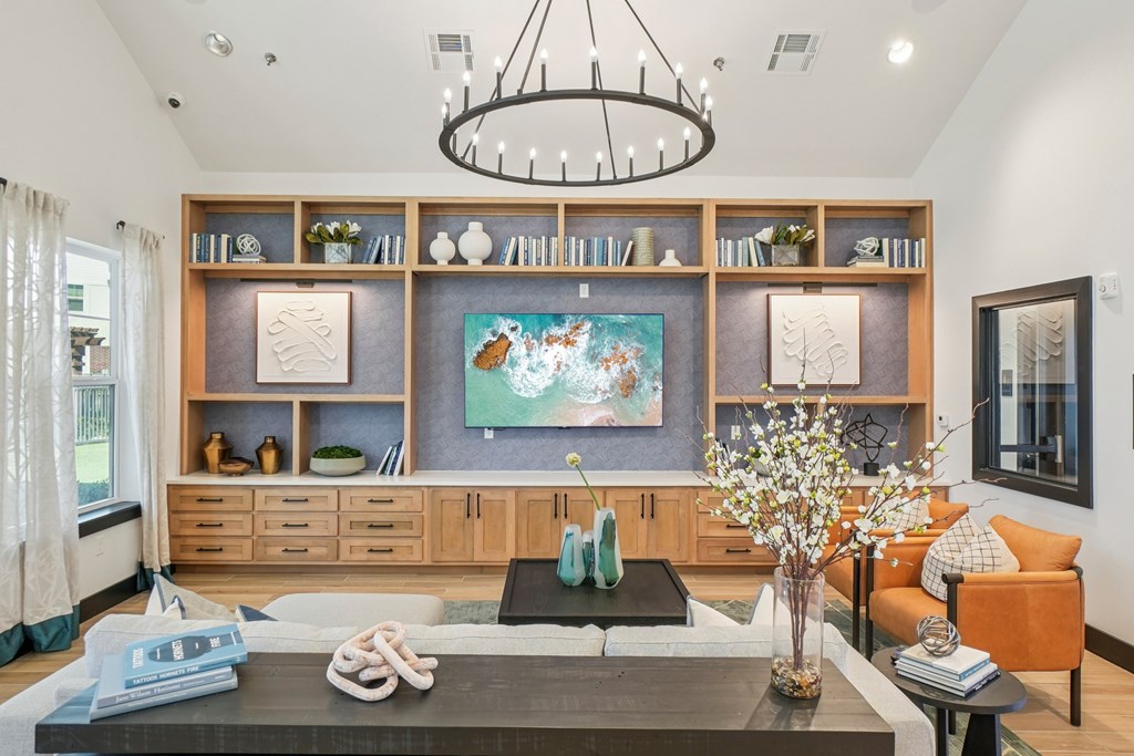 A modern living room with a large painting on the wall and a coffee table in the center.