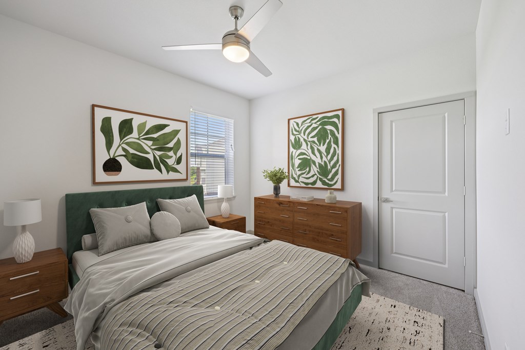 A bedroom with a bed, nightstand, and a ceiling fan.