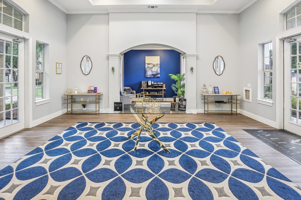 A room with a blue and white patterned rug in the center.