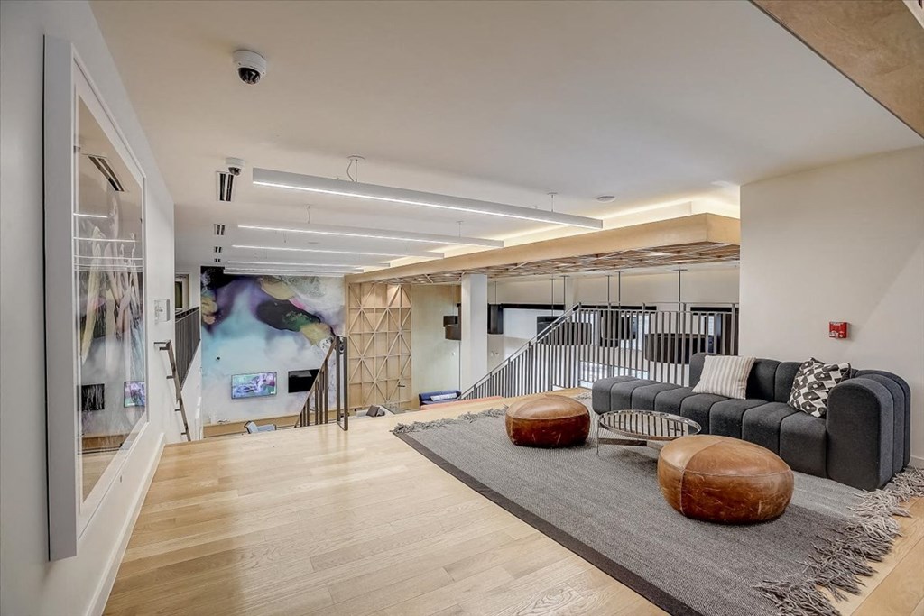 a living room with a couch and a rug and a staircase