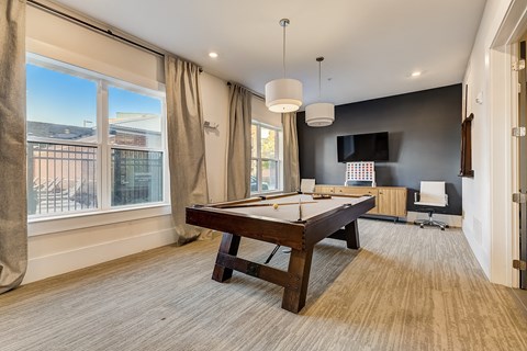 A room with a pool table and a chair.