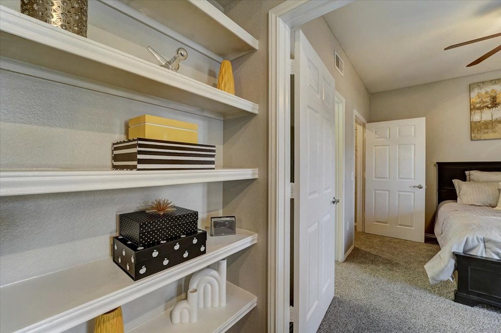 a bedroom with a closet and a bed and shelves with